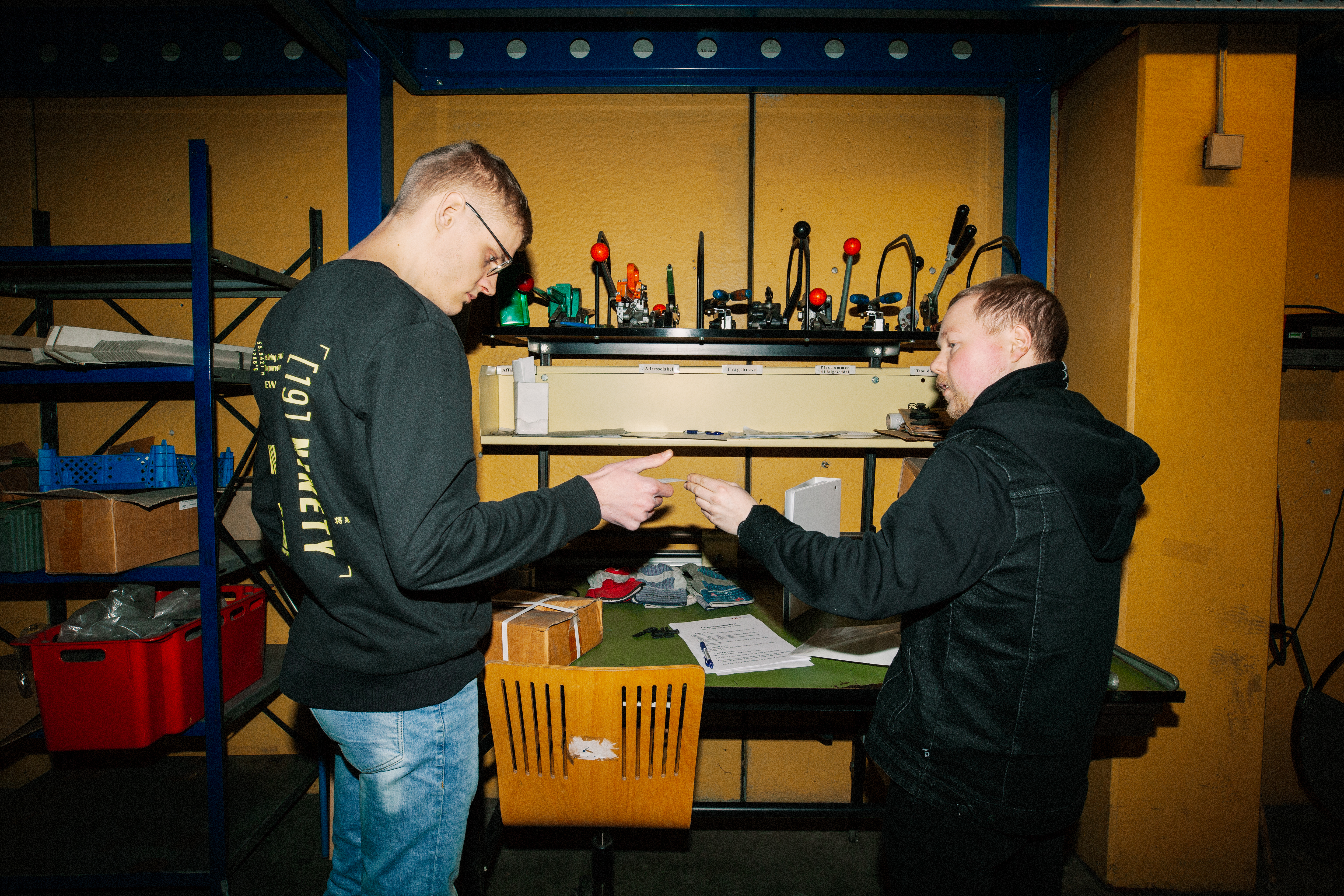 En lærling modtager instruktioner fra en kollega på lageret, lærling, instruktion, lagerarbejde, kollegaer, logistik, lager